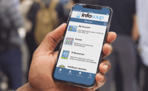 person holding phone with InfoSoup App opened