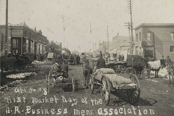 old black & white photo of horses pulling carts & wagons